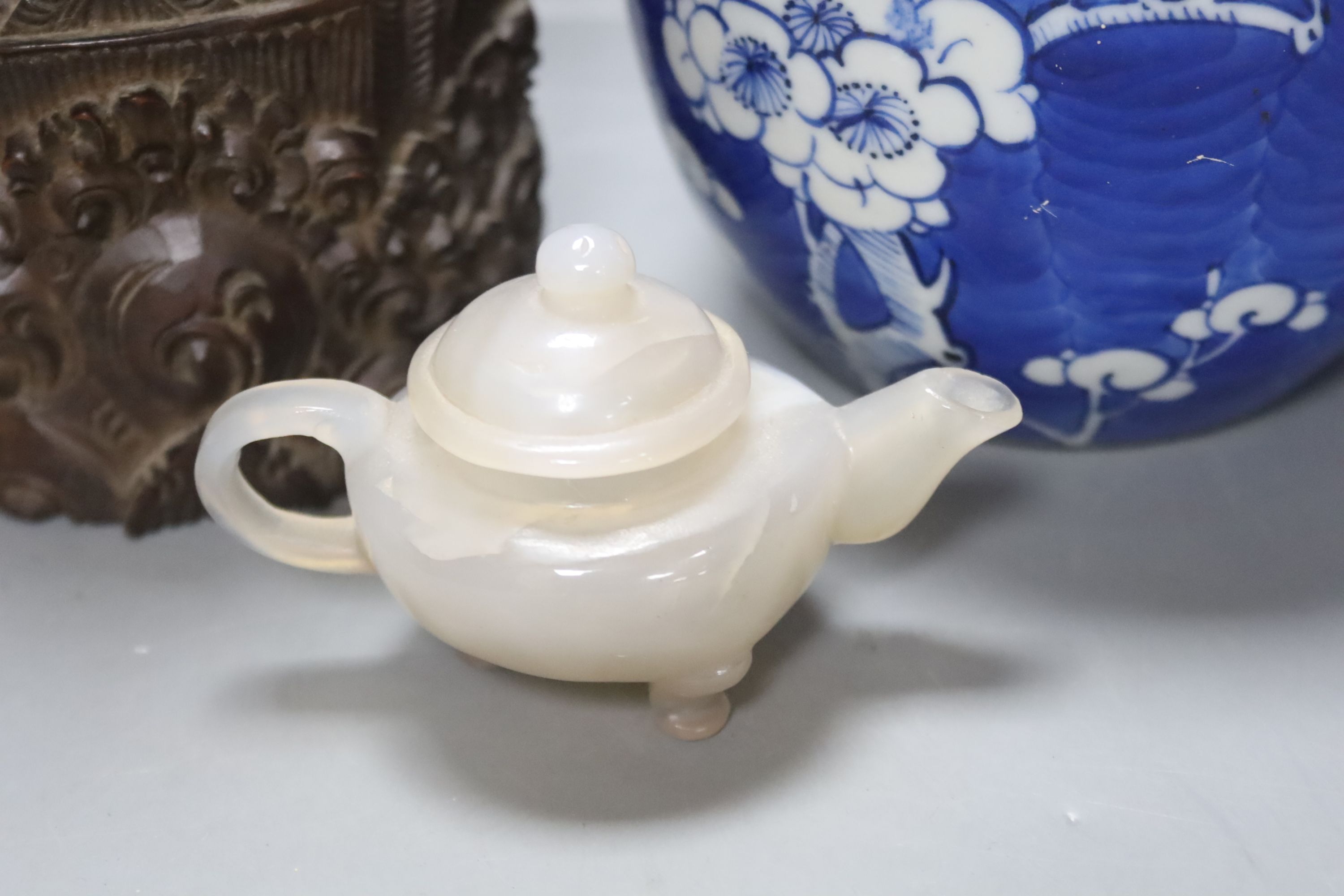 Two early 20th century Chinese blue and white jars, an agate miniature teapot and an Indonesian wood carving, length 27.5cm